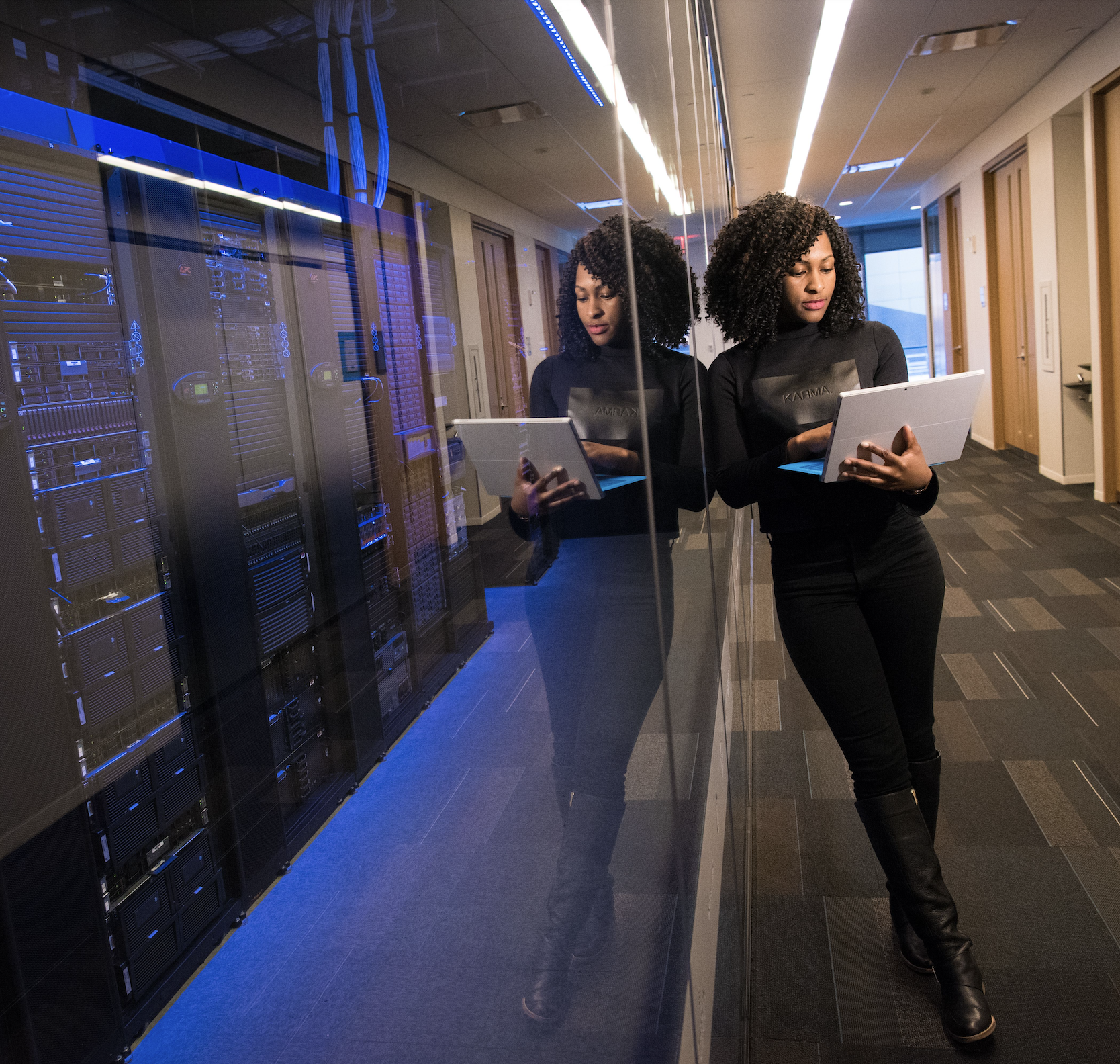 A data engineer reviewing a laptop beside an active server rack